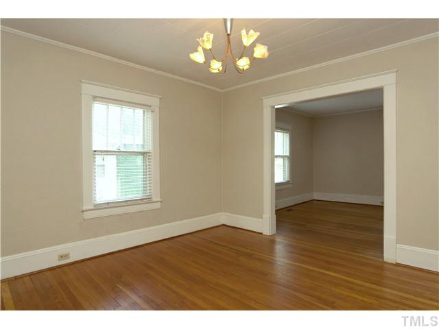 124 Hudson Street Raleigh, NC 27608 - Photo 6 of 19 an empty room with wooden floor and windows