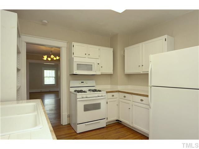 124 Hudson Street Raleigh, NC 27608 - Photo 8 of 19 a kitchen with white cabinets and white appliances