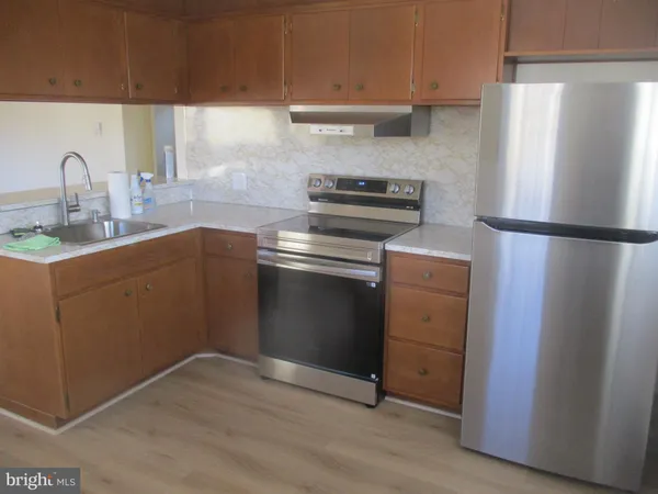 a kitchen with a refrigerator sink and cabinets