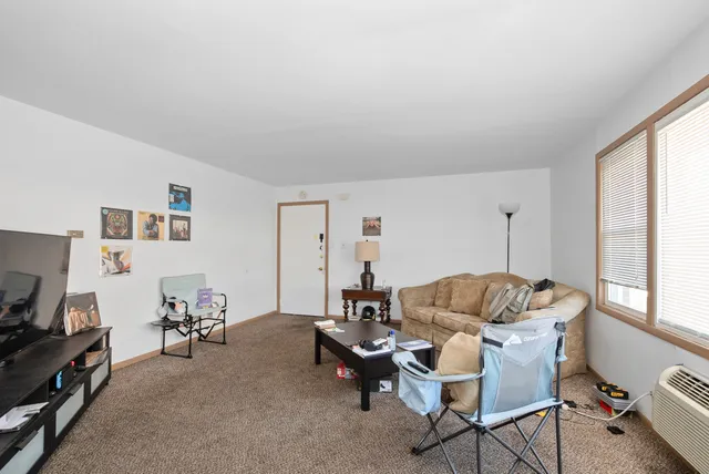 a living room with furniture a flat screen tv and a window