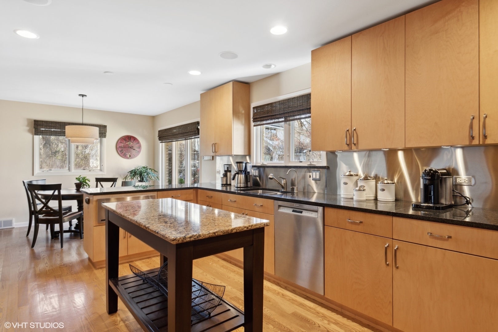 920 Pine Tree Lane Winnetka, IL 60093 - Photo 21 of 59 a kitchen with stainless steel appliances granite countertop a stove top oven a sink a dining table and chairs with wooden floor