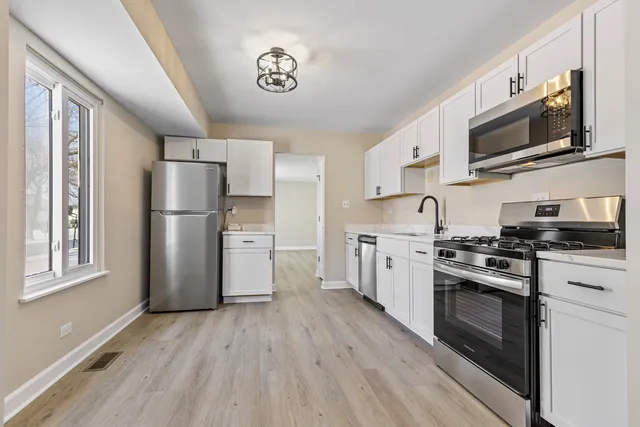 a kitchen with stainless steel appliances a refrigerator stove and microwave