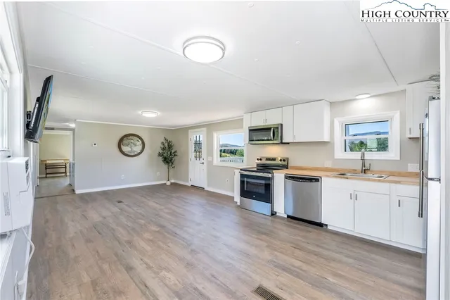 a large kitchen with cabinets wooden floor and stainless steel appliances