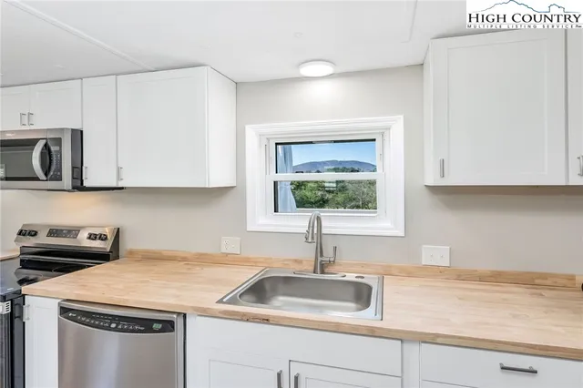 a kitchen with stainless steel appliances granite countertop a sink a stove and a microwave