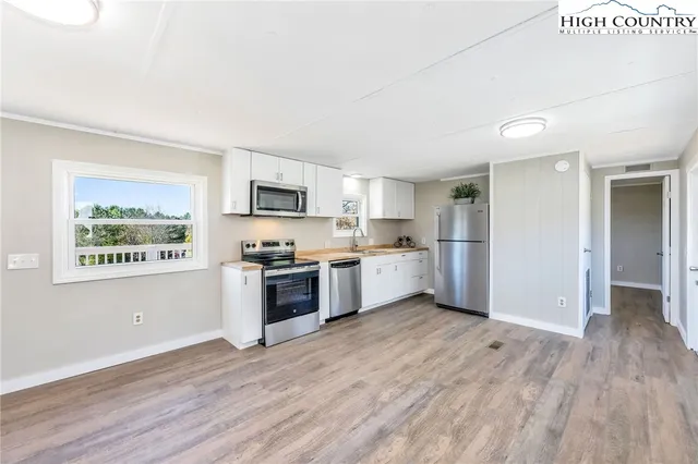 a view of kitchen with wooden floor and electronic appliances