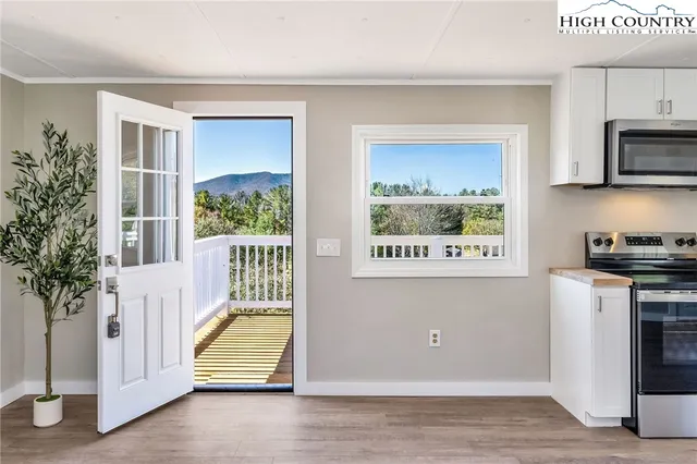 a view of a hallway with entryway wooden floor and windows