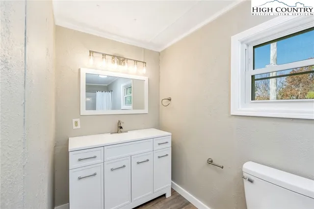 a bathroom with a toilet a sink a vanity and mirror