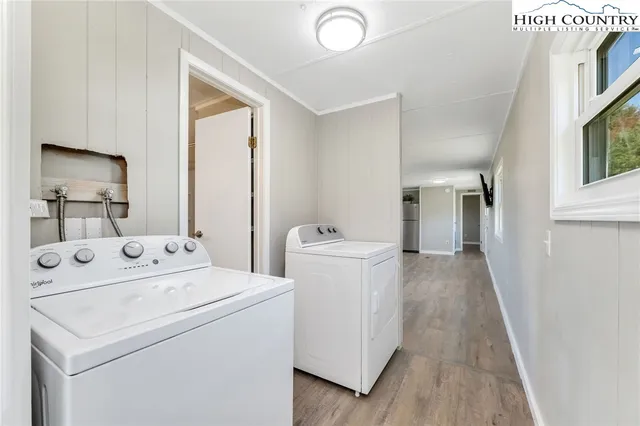 a view of washer and dryer with bathroom in the background