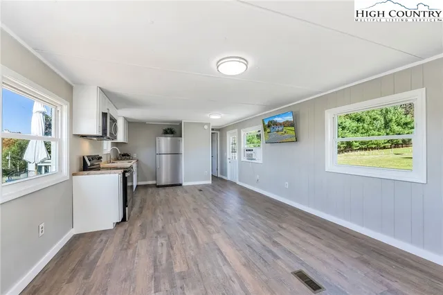 a view of a kitchen with wooden floor and stainless steel appliances