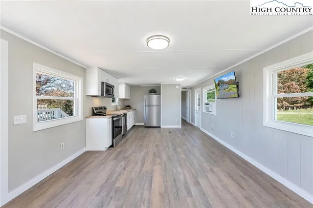 a view of a kitchen with wooden floor and windows