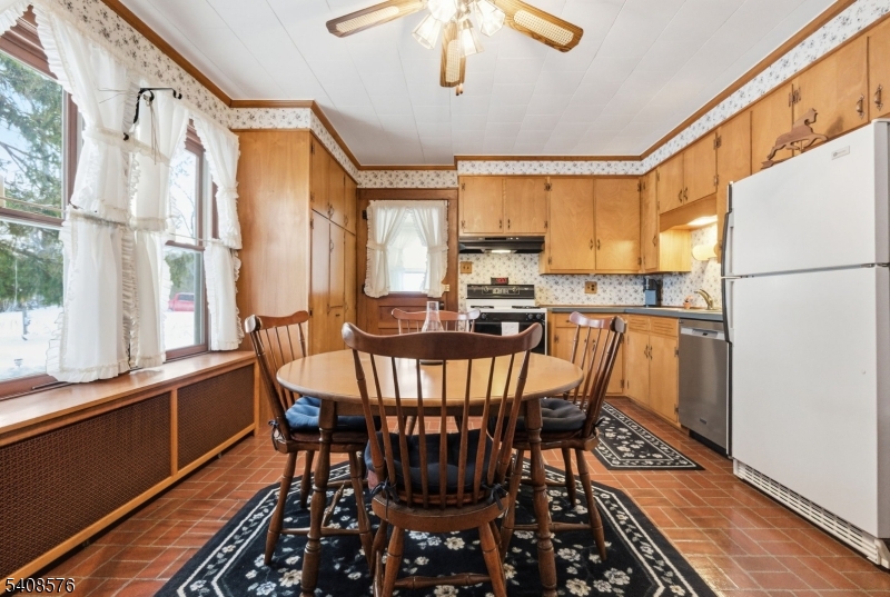 203 Johnsonburg Road Andover, NJ 07821 - Photo 17 of 42 a kitchen with stainless steel appliances a dining table chairs sink and wooden floor