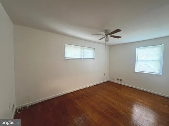 an empty room with a window and a ceiling fan