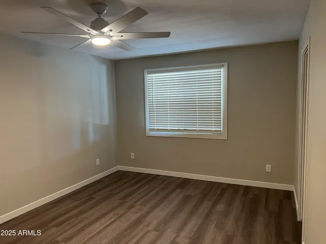 an empty room with wooden floor and a window