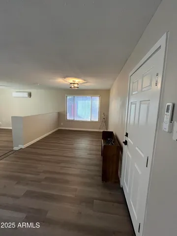 a view of a hallway to room with wooden floor and stairs