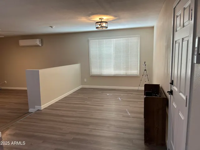 a view of a livingroom with wooden floor and a ceiling fan