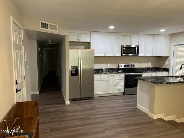 a kitchen with stainless steel appliances a refrigerator stove and sink