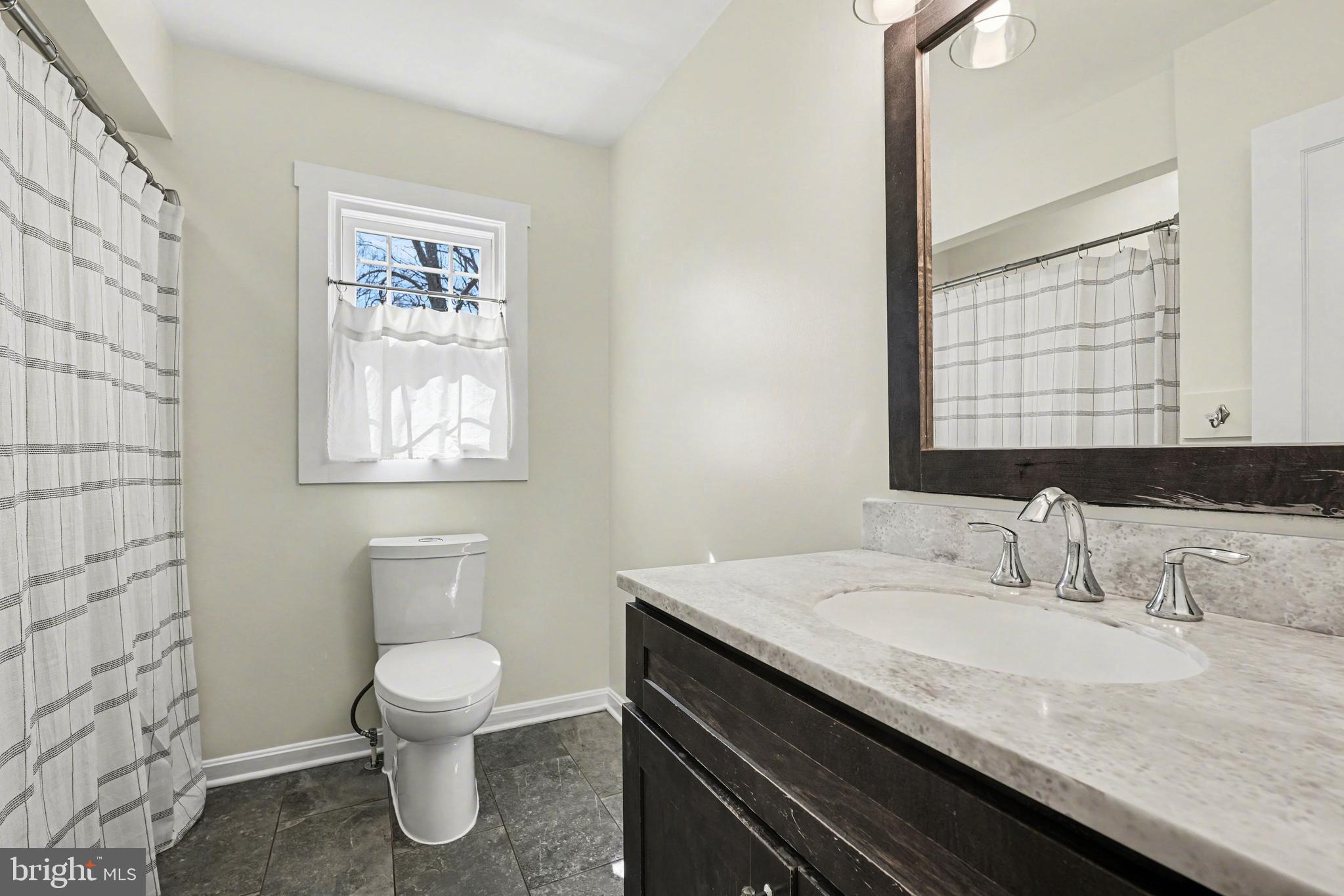 11080 Dutch Hollow Road Culpeper, VA 22701 - Photo 18 of 28 a bathroom with a granite countertop sink a toilet and a window