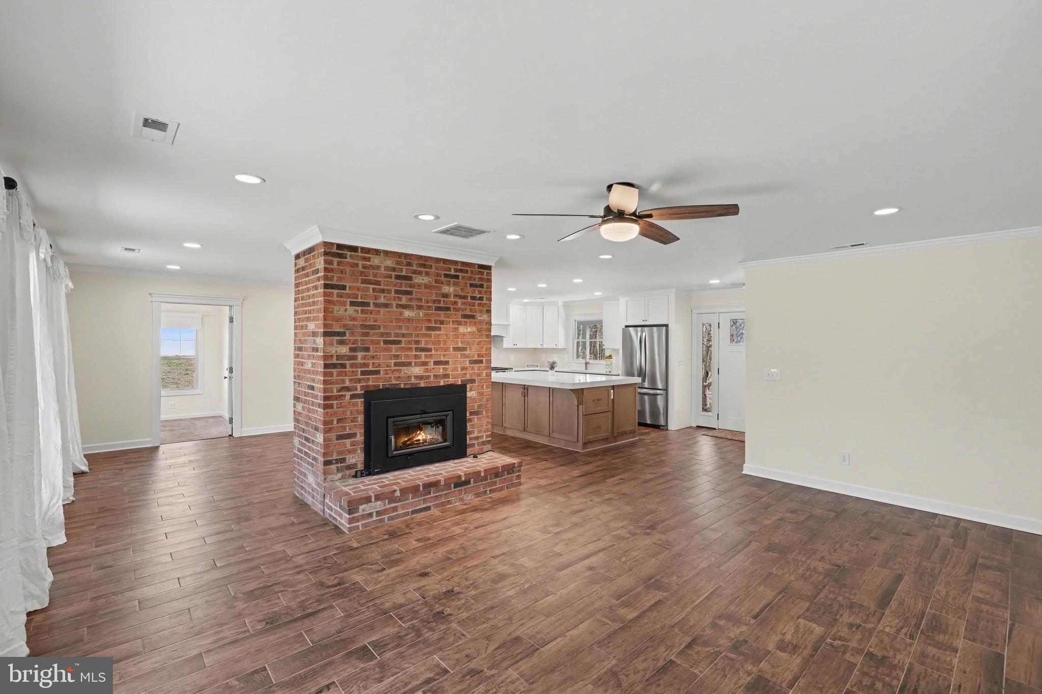 11080 Dutch Hollow Road Culpeper, VA 22701 - Photo 6 of 28 a view of a livingroom with a fireplace a ceiling fan and windows