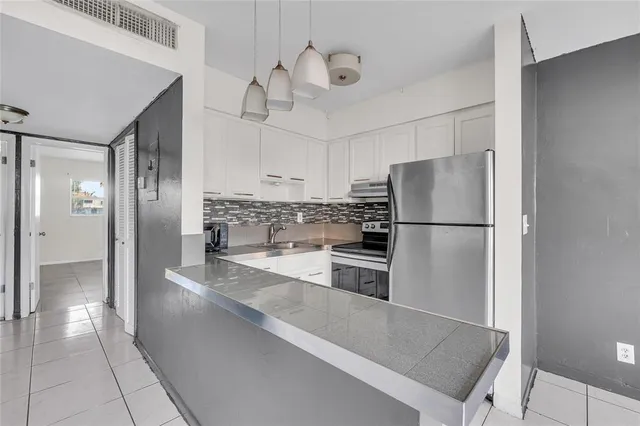 a kitchen with granite countertop a refrigerator and a sink