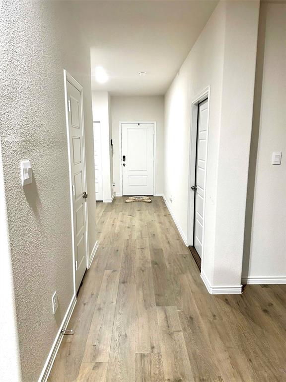 324 Revolution Road Fate, TX 75189 - Photo 6 of 15 Hallway featuring wood-finish flooring, white paneled doors, recessed lighting, and crisp white baseboards