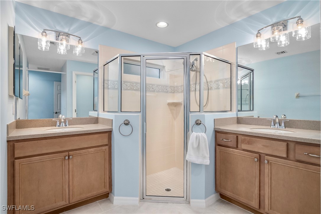 19642 Villa Rosa Loop Estero, FL 33967 - Photo 13 of 27 a bathroom with a double vanity sink and mirror with shower
