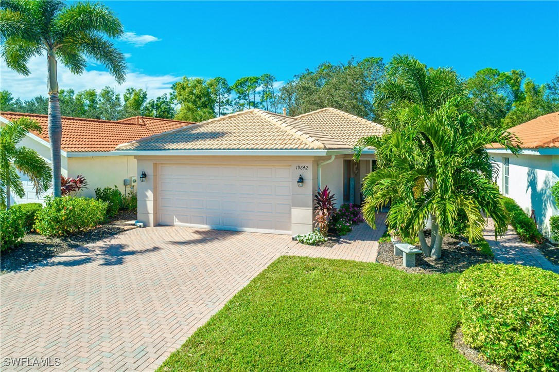 19642 Villa Rosa Loop Estero, FL 33967 - Photo 5 of 27 a front view of a house with a garden and plants