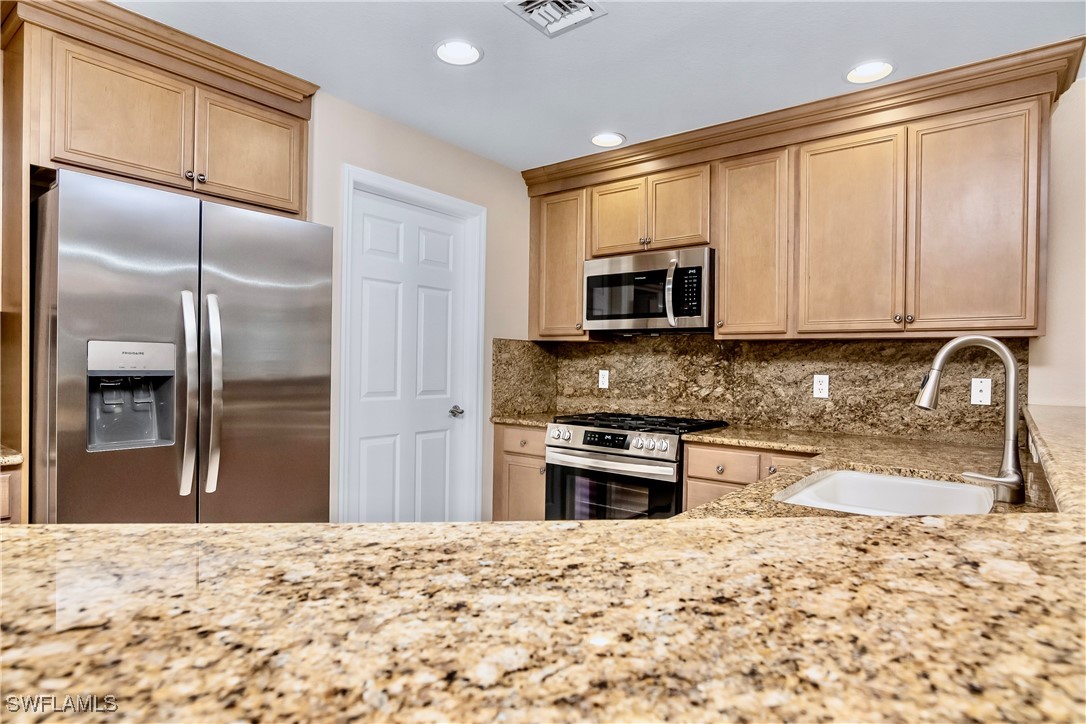 19642 Villa Rosa Loop Estero, FL 33967 - Photo 6 of 27 a kitchen with granite countertop a refrigerator stove top oven and sink