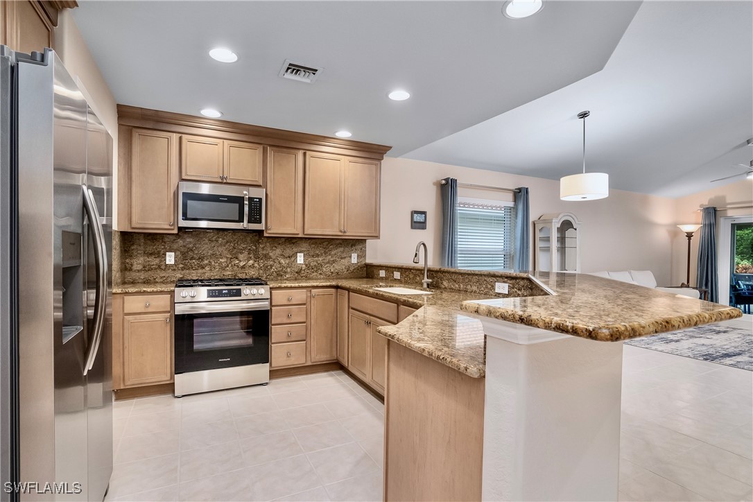 19642 Villa Rosa Loop Estero, FL 33967 - Photo 7 of 27 a large kitchen with granite countertop a stove sink and refrigerator