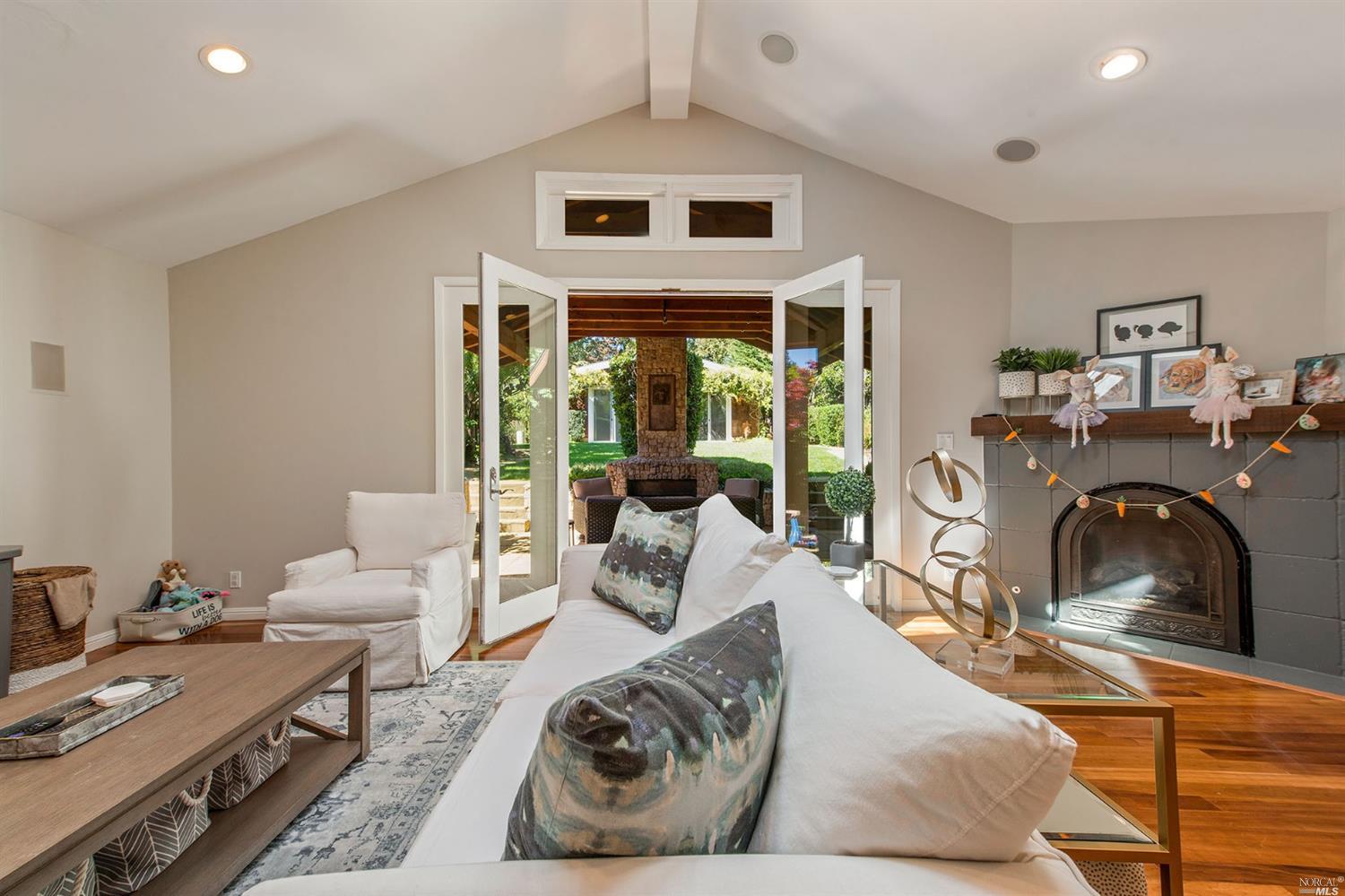 a living room with furniture fireplace and a large window