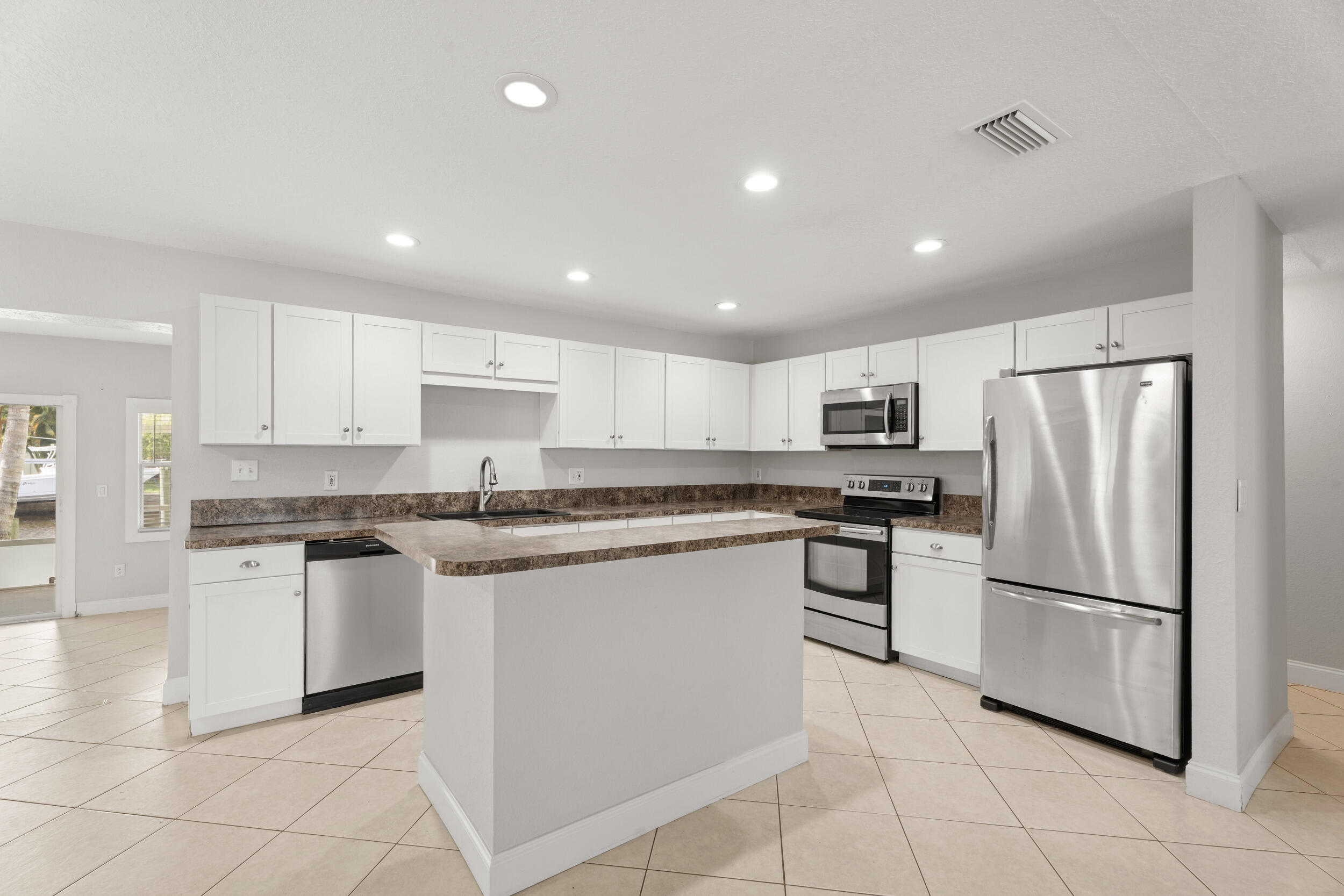1459 Southwest Seahawk Way Palm City, FL 34990 - Photo 8 of 43 a kitchen with stainless steel appliances granite countertop a refrigerator sink and stove