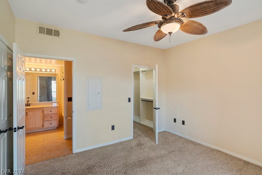 10001 Peace Way, Unit 2311 Las Vegas, NV 89147 - Photo 17 of 35 Unfurnished bedroom featuring light carpet, a spacious closet, electric panel, a ceiling fan, and light tile patterned floors