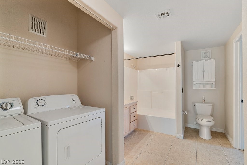 10001 Peace Way, Unit 2311 Las Vegas, NV 89147 - Photo 21 of 35 Laundry area with light tile patterned floors and washer and dryer