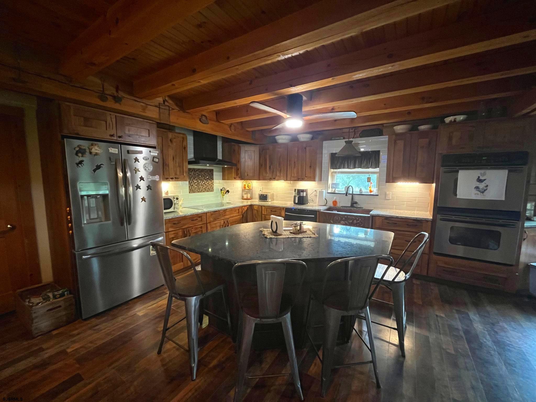 308 Willis Road Bridgeton, NJ 08302 - Photo 18 of 38 a kitchen with stainless steel appliances wooden floor dining table and chairs