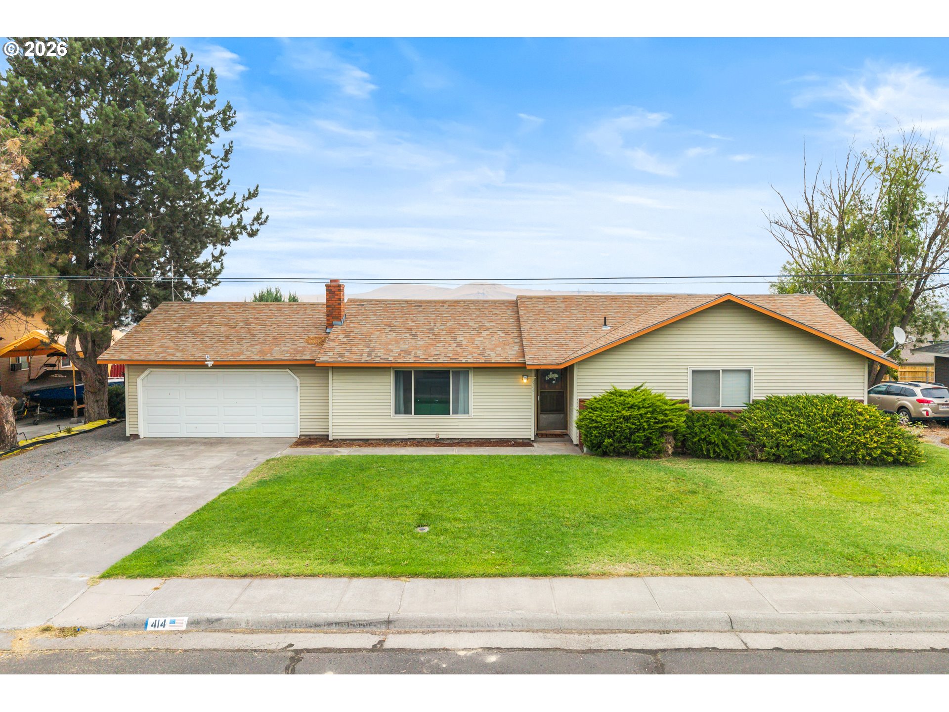 414 Monroe Street Umatilla, OR 97882 - Photo 1 of 19 a front view of a house with garage and green space