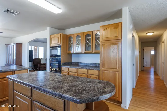 a dining room with wooden floor and stainless steel appliances