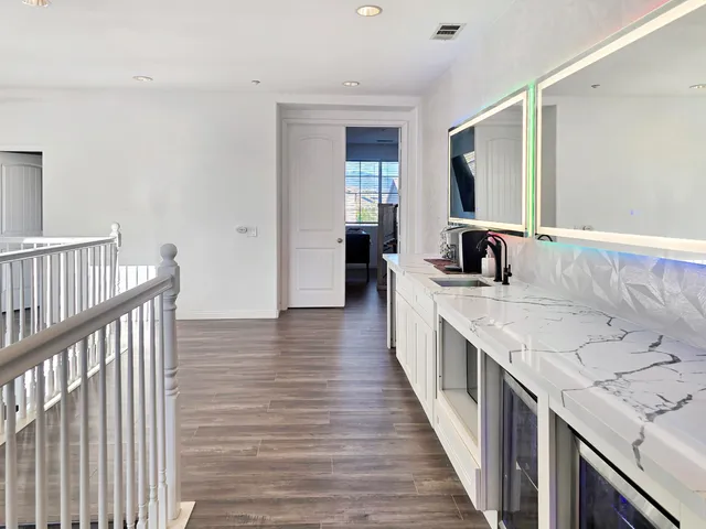 a view of an empty room with wooden floor and cabinet