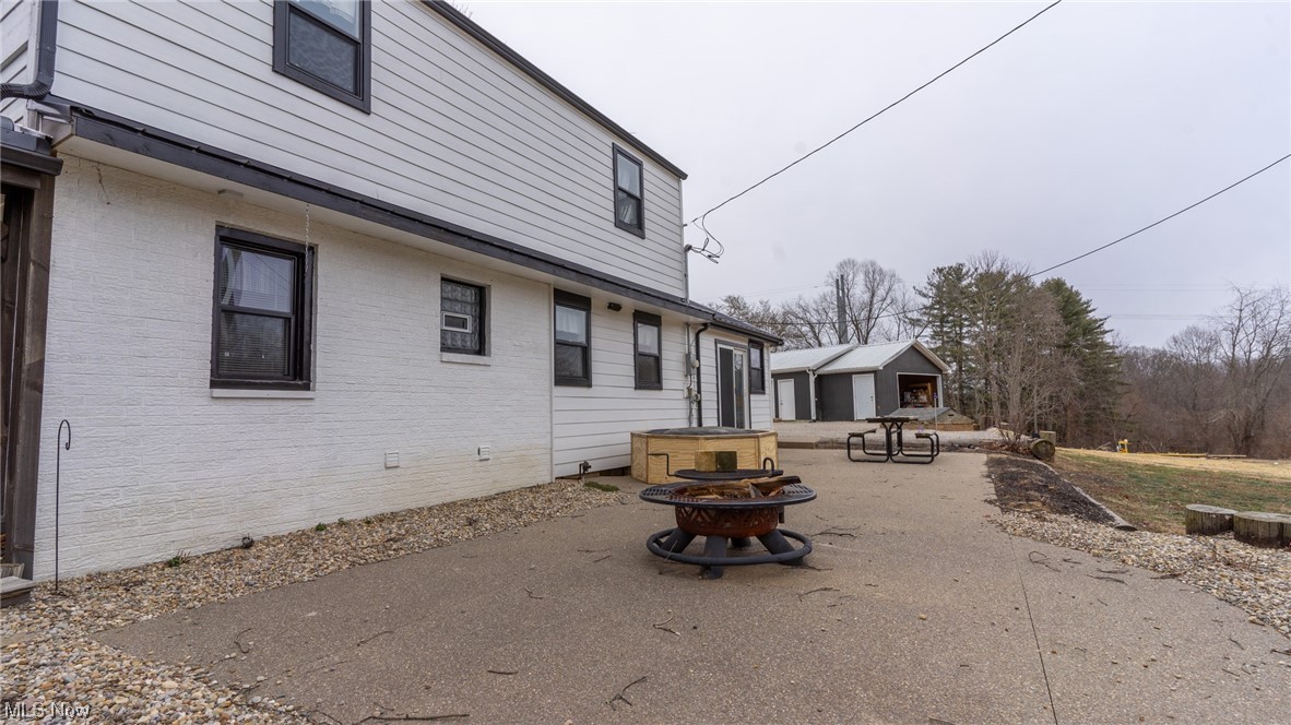 13962 Nickel Plate Road Logan, OH 43138 - Photo 34 of 46 Back of property with an outdoor fire pit and a patio