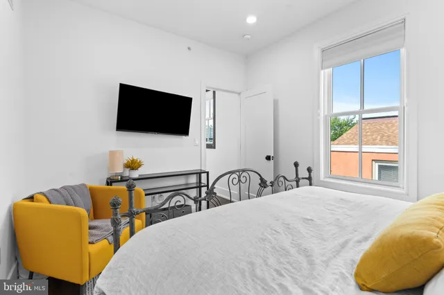 a bedroom with bed and a flat screen tv