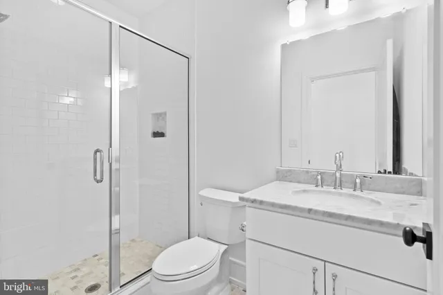 a bathroom with a sink toilet vanity and shower