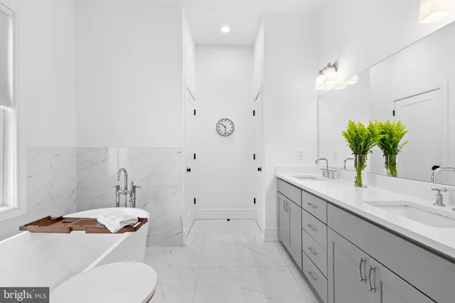a bathroom with a granite countertop sink mirror and toilet