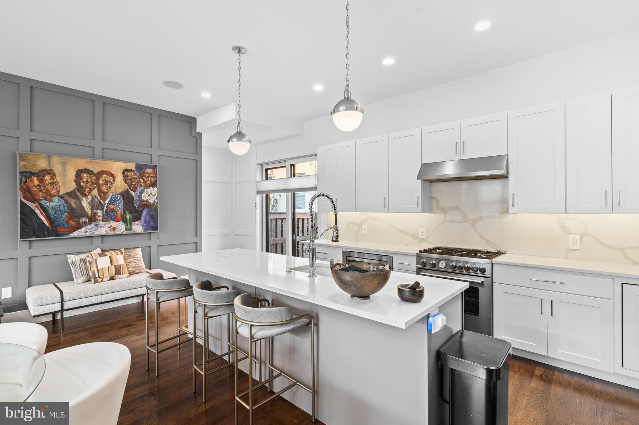 606 North 16th Street Philadelphia, PA 19130 - Photo 10 of 43 a kitchen with a stove a refrigerator and a dining table with wooden floor