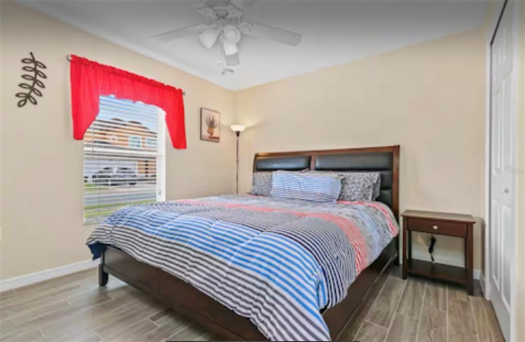 100 Cardinal Court Davenport, FL 33896 - Photo 17 of 30 a bedroom with a bed and wooden floor