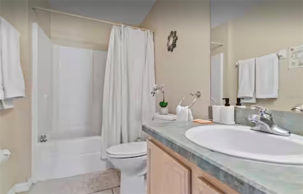 100 Cardinal Court Davenport, FL 33896 - Photo 24 of 30 a bathroom with a granite countertop sink a toilet and shower