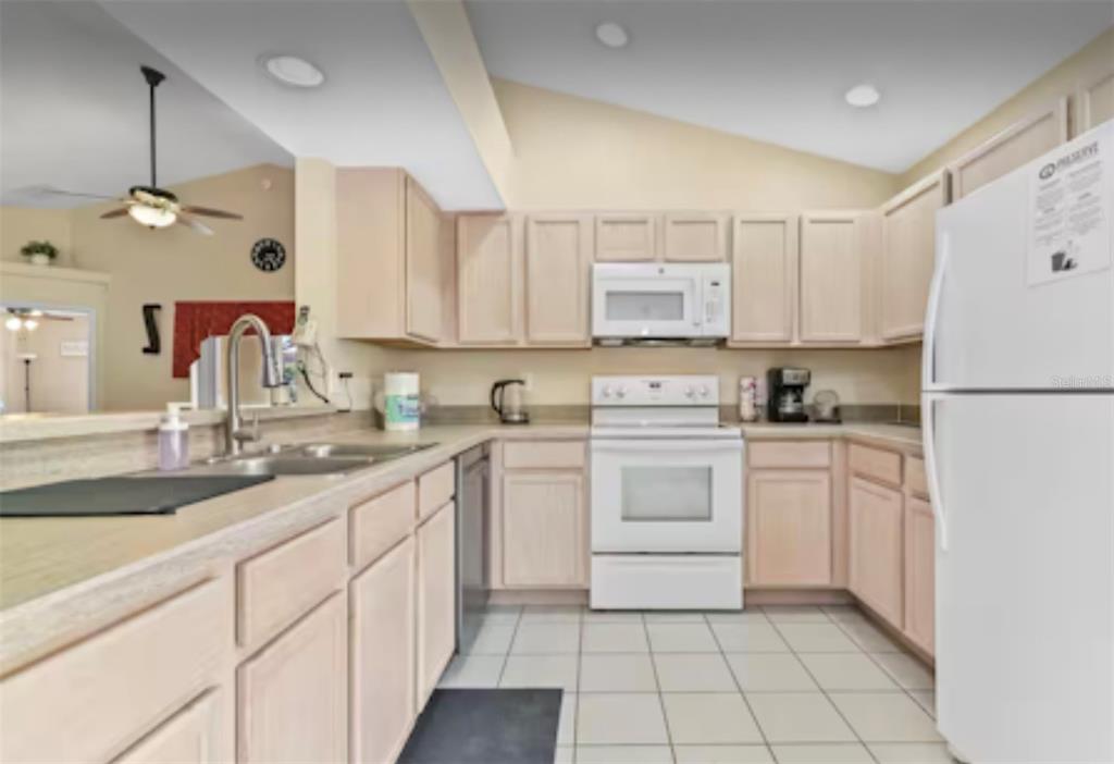 100 Cardinal Court Davenport, FL 33896 - Photo 4 of 30 a kitchen with a sink window and white cabinets