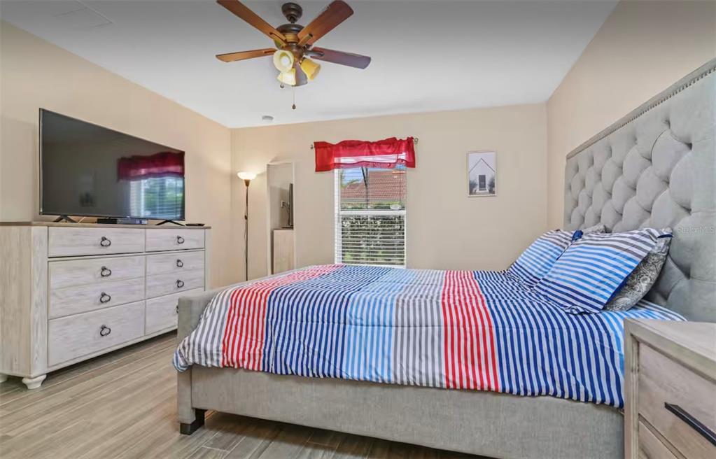100 Cardinal Court Davenport, FL 33896 - Photo 5 of 30 a bedroom with a bed and a flat screen tv