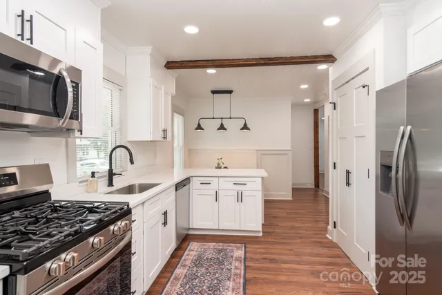 a kitchen with stainless steel appliances granite countertop a stove a sink and a refrigerator