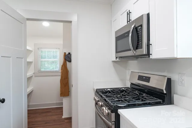a kitchen with white cabinets and black appliances
