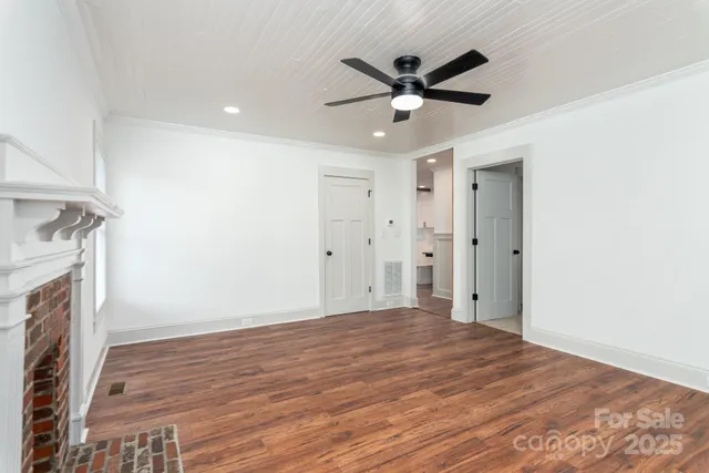 a view of a livingroom with a ceiling fan wooden floor and a ceiling fan