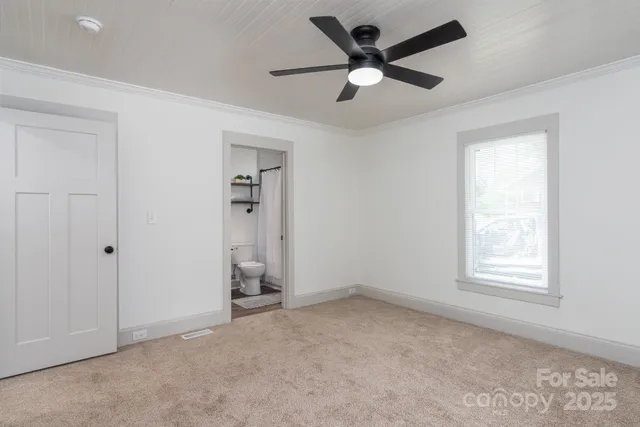 an empty room with closet and windows