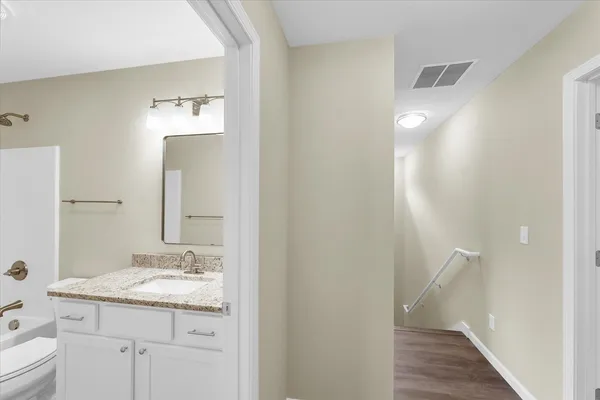 a bathroom with a granite countertop sink toilet and shower